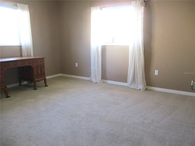 unfurnished office featuring carpet floors and baseboards