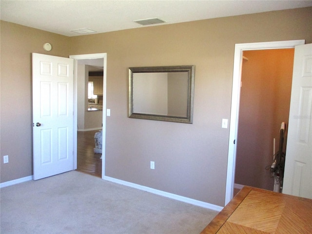 unfurnished bedroom featuring carpet floors, baseboards, and visible vents