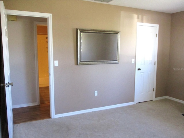 unfurnished bedroom with carpet, visible vents, and baseboards