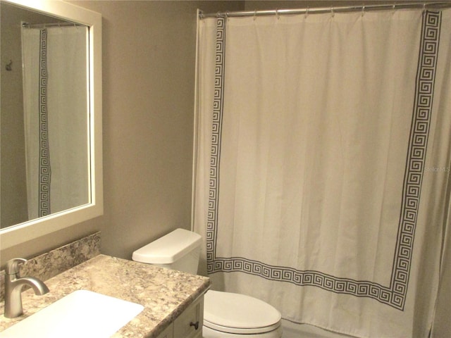 bathroom with toilet, curtained shower, and vanity