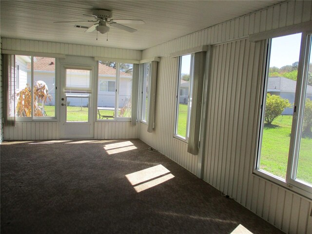 unfurnished sunroom featuring ceiling fan