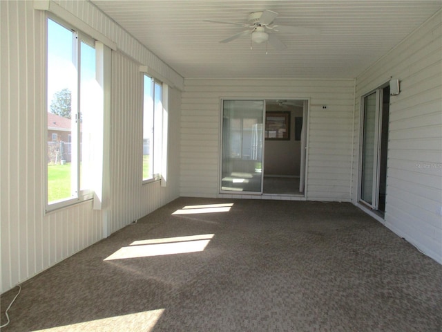 unfurnished sunroom featuring ceiling fan