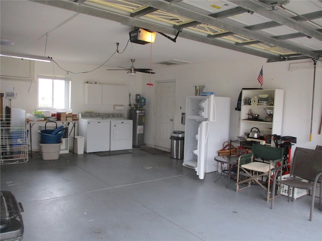 garage featuring water heater, a garage door opener, and washer and dryer