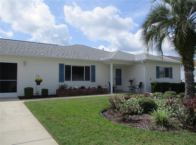 single story home featuring a front lawn and roof with shingles