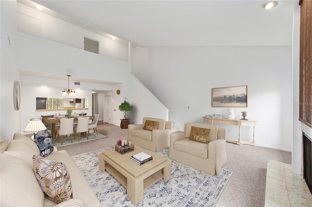 living room with vaulted ceiling, a brick fireplace, light carpet, and a notable chandelier