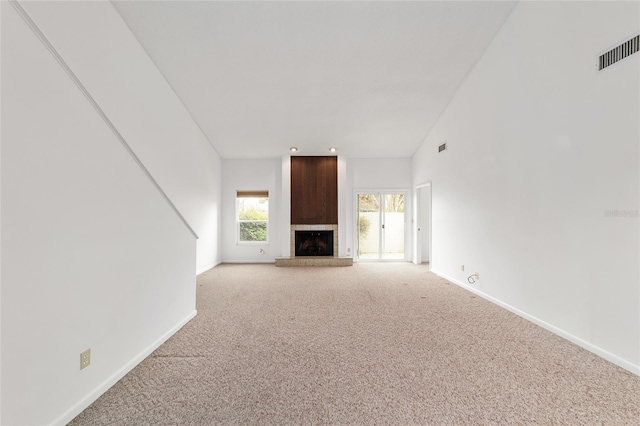 unfurnished living room featuring light colored carpet and a fireplace