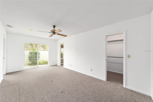 carpeted spare room with ceiling fan and a textured ceiling