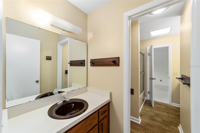 bathroom with vanity, wood-type flooring, and an enclosed shower