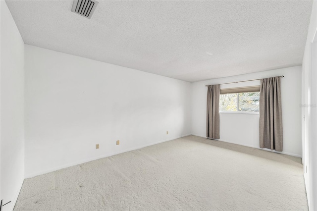 carpeted empty room featuring a textured ceiling