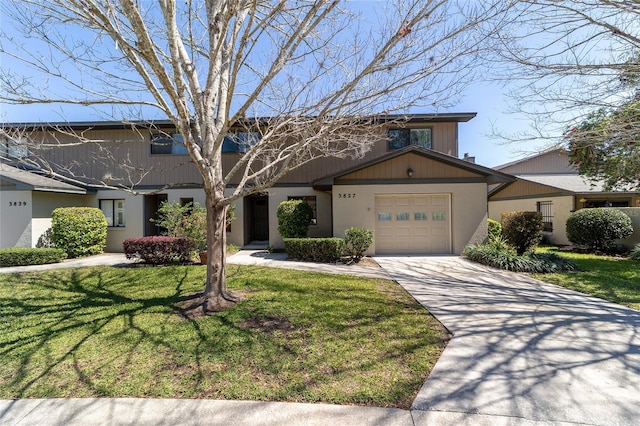 view of front of property featuring a garage, concrete driveway, and a front yard