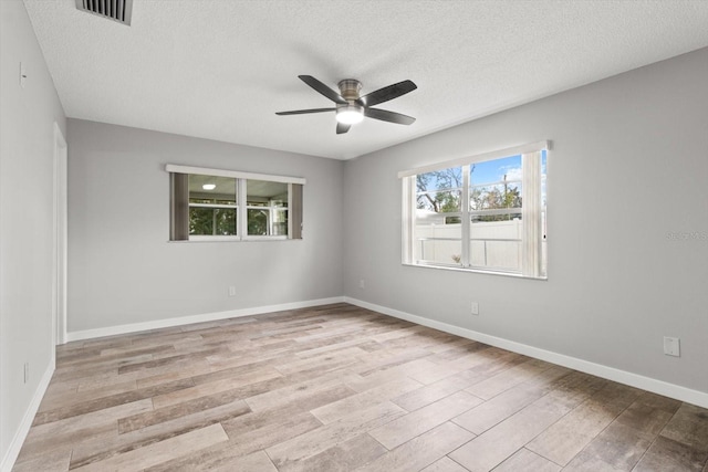 unfurnished room featuring a textured ceiling, ceiling fan, and light hardwood / wood-style floors