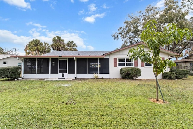 back of property featuring a sunroom and a yard