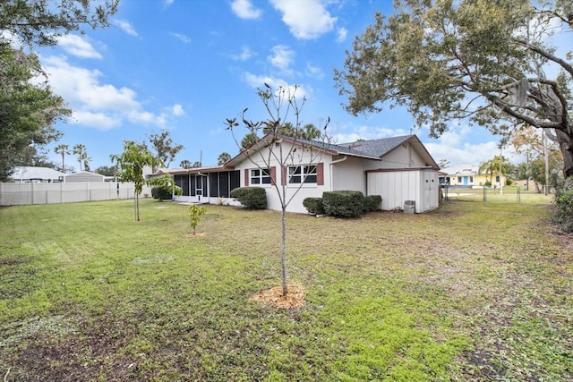 rear view of property with a yard and a sunroom