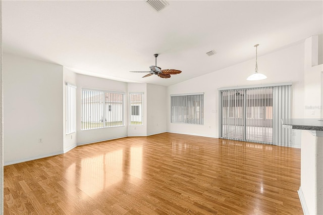 unfurnished living room featuring ceiling fan, vaulted ceiling, and light wood-type flooring