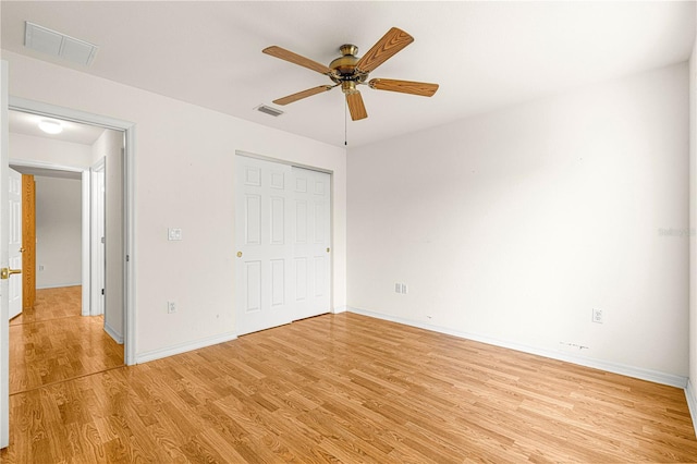 unfurnished bedroom with light wood-type flooring, ceiling fan, and a closet