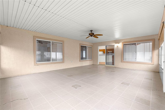 unfurnished sunroom featuring ceiling fan