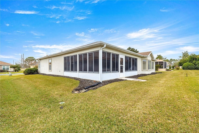 back of property with a sunroom and a yard