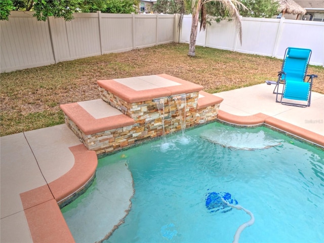 view of pool with pool water feature, a lawn, and a patio area