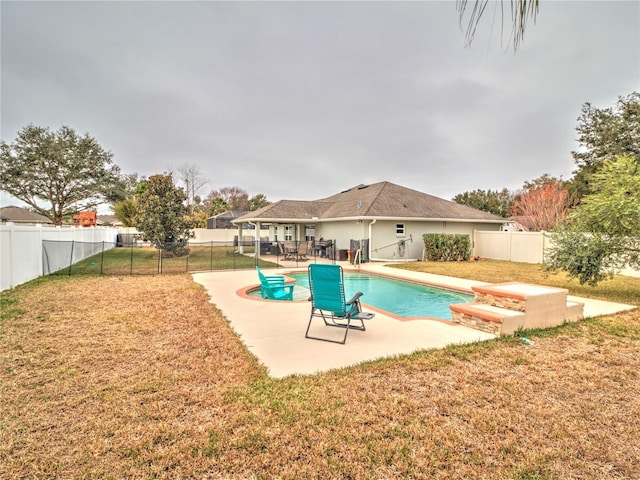 view of pool featuring a lawn and a patio