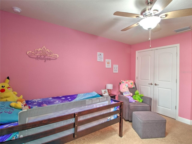 carpeted bedroom featuring ceiling fan and a closet