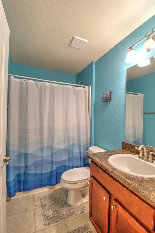 bathroom with vanity, tile patterned floors, toilet, and a textured ceiling