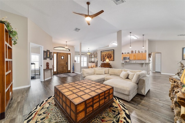 living room featuring ceiling fan, lofted ceiling, dark wood-type flooring, and a textured ceiling