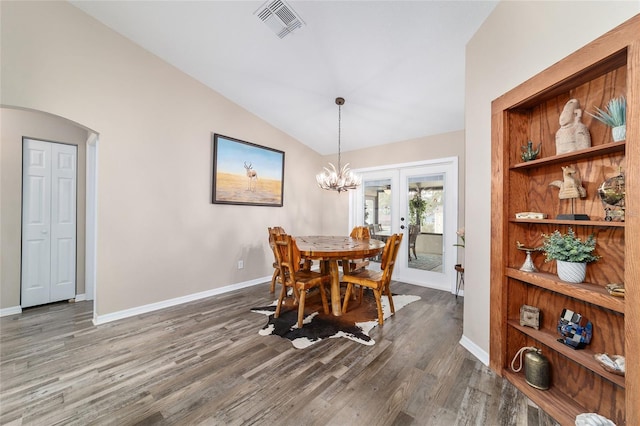 dining room with vaulted ceiling, built in features, a chandelier, dark hardwood / wood-style flooring, and french doors