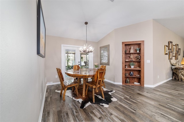 dining room featuring hardwood / wood-style flooring, vaulted ceiling, built in features, and an inviting chandelier