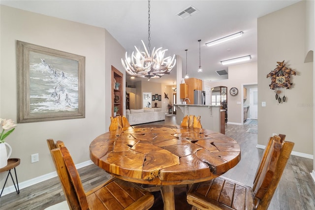 dining area with an inviting chandelier and dark hardwood / wood-style floors