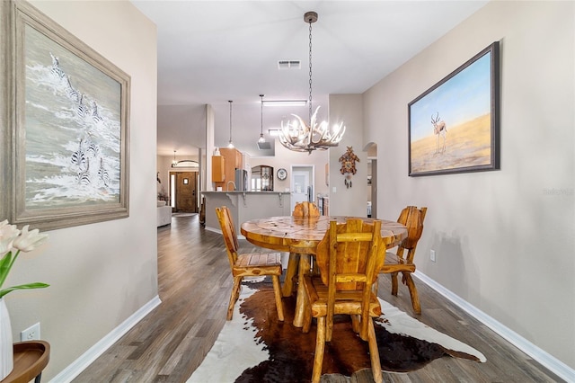 dining space featuring dark hardwood / wood-style floors and a notable chandelier