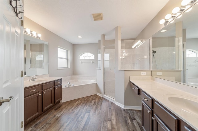 bathroom with hardwood / wood-style flooring, vanity, and shower with separate bathtub