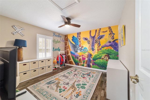 game room featuring dark hardwood / wood-style flooring, a textured ceiling, and ceiling fan