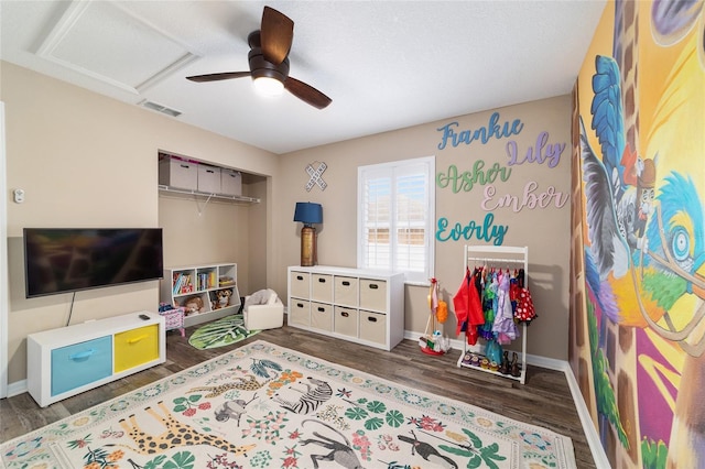 playroom with ceiling fan and dark hardwood / wood-style flooring