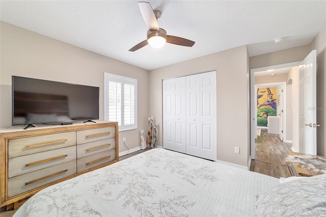 bedroom with dark hardwood / wood-style flooring, a closet, and ceiling fan