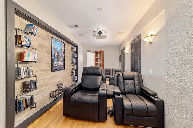 cinema featuring hardwood / wood-style flooring and wood walls