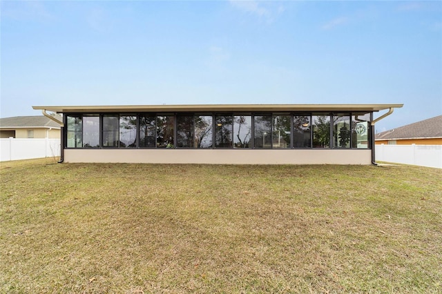 view of front facade featuring a sunroom and a front yard