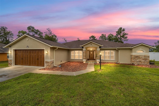 single story home with driveway, a garage, stone siding, stucco siding, and a front yard