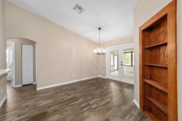 unfurnished dining area featuring arched walkways, dark wood-type flooring, visible vents, baseboards, and french doors