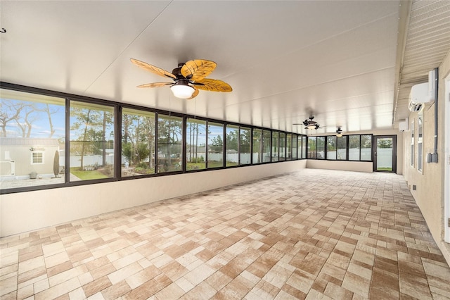 unfurnished sunroom featuring a wall unit AC and ceiling fan