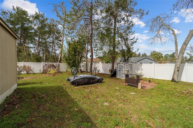 view of yard with a fenced backyard, a shed, and an outdoor structure