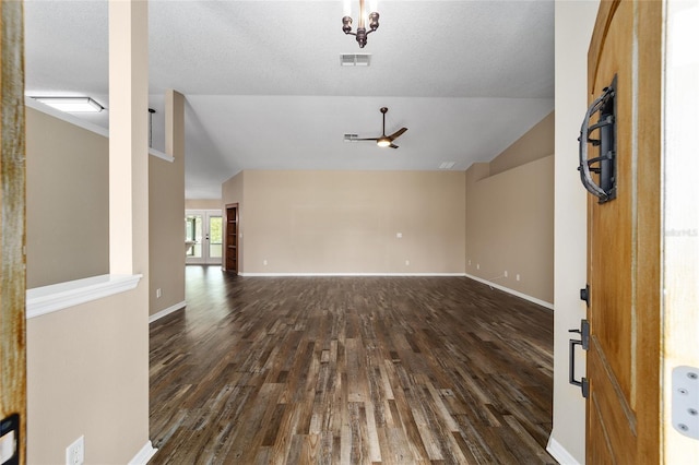 spare room with lofted ceiling, baseboards, visible vents, and dark wood-type flooring