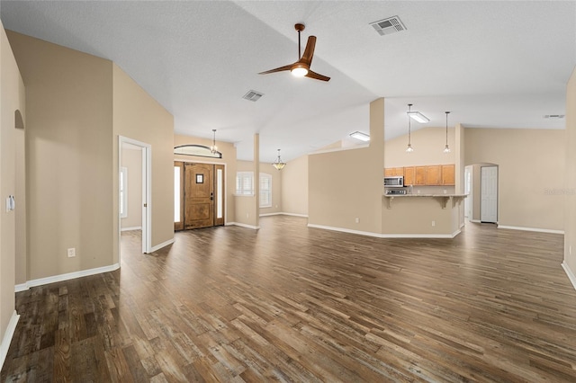 unfurnished living room with visible vents, arched walkways, dark wood finished floors, and ceiling fan with notable chandelier