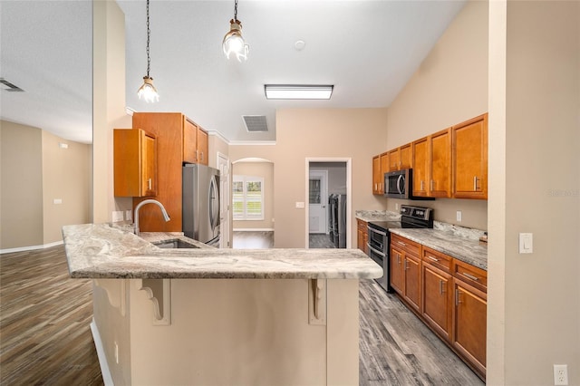 kitchen with visible vents, a breakfast bar, a peninsula, stainless steel appliances, and a sink