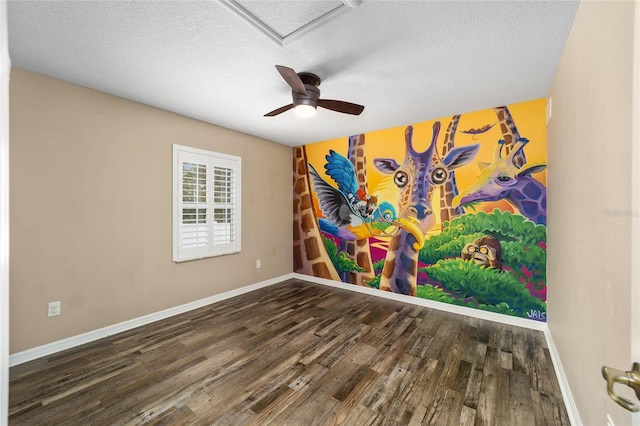 unfurnished room with a textured ceiling, wood finished floors, a ceiling fan, and baseboards