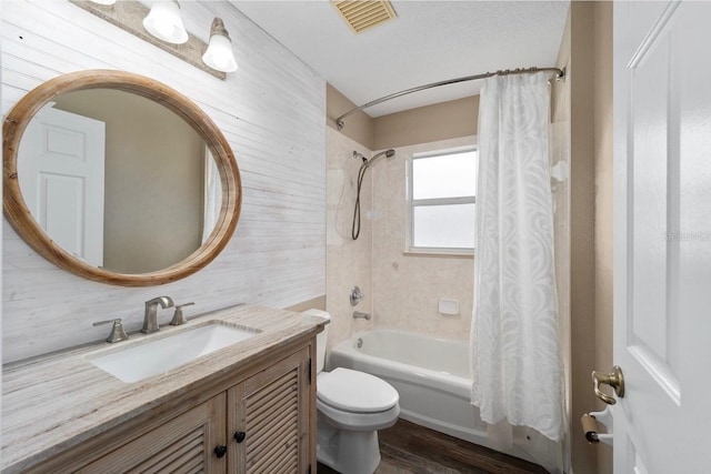 full bath with toilet, shower / tub combo, wood finished floors, vanity, and visible vents