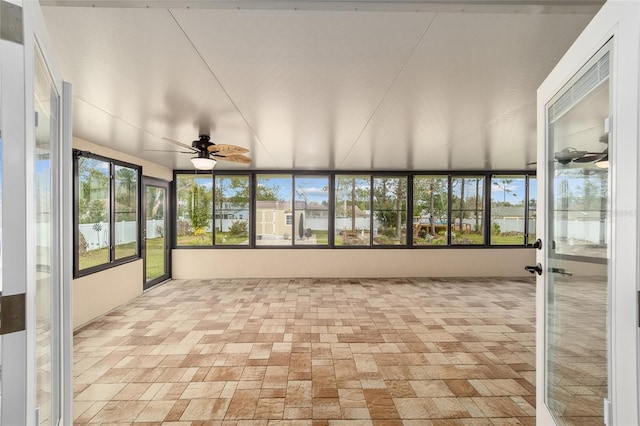 unfurnished sunroom featuring ceiling fan