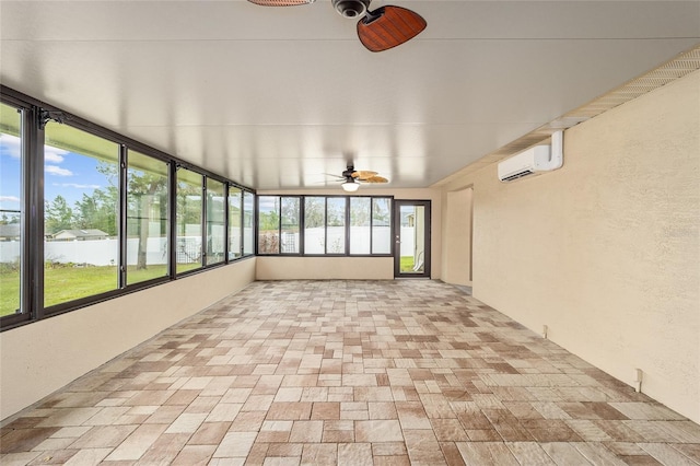 unfurnished sunroom featuring a wall unit AC and ceiling fan