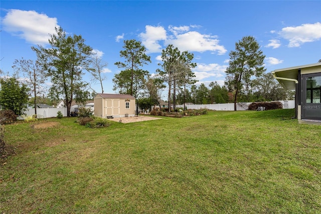 view of yard with an outbuilding, a fenced backyard, and a storage unit