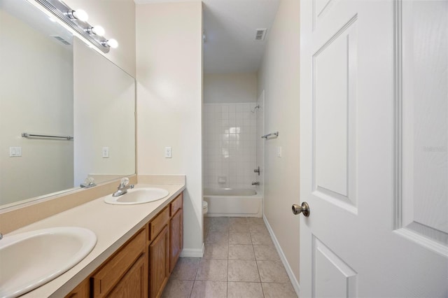 full bathroom featuring tile patterned flooring, vanity, tiled shower / bath, and toilet