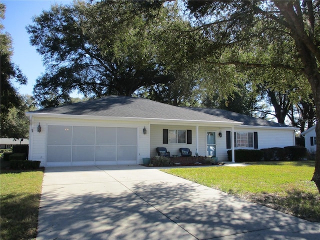 ranch-style house featuring a garage, concrete driveway, and a front yard